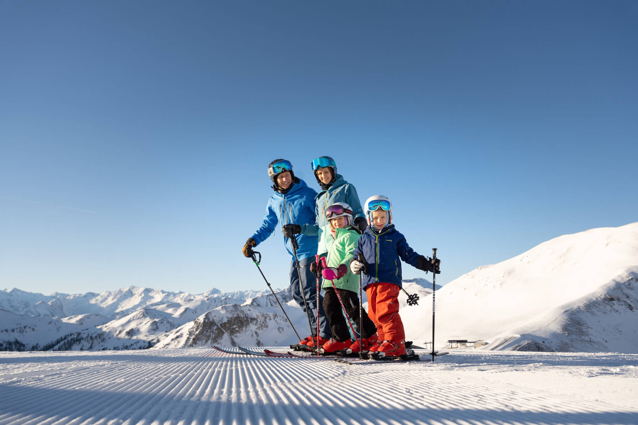 Familie beim Skifahren in den österreichischen Bergen, ideal für Winterurlaub im Hotel Barbarahof.